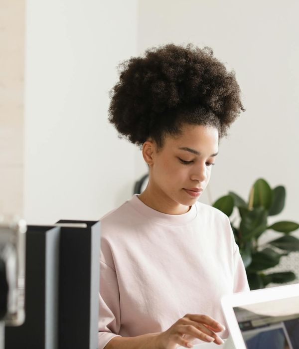 Woman doing a gentle yoga stretch at her office desk.